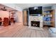 Inviting living room featuring a stone fireplace, large-screen TV, and wood-look flooring at 413 Valencia Rd, Venice, FL 34285