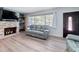 Relaxing living room featuring a stone fireplace, modern seating, and laminate floors at 413 Valencia Rd, Venice, FL 34285