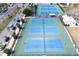 Aerial view of several blue and green community tennis courts with palm trees at 413 Valencia Rd, Venice, FL 34285