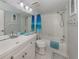 Clean bathroom with a white vanity, a large mirror, and a shower-tub combination with bright blue accents at 418 Cerromar Ct # 158, Venice, FL 34293