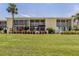 Condo building's rear exterior showcasing manicured lawn and screened lanais at 418 Cerromar Ct # 158, Venice, FL 34293