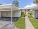 Inviting condo exterior with a carport, landscaped walkway, and second-story balconies in a bright, sunny setting at 418 Cerromar Ct # 158, Venice, FL 34293