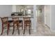 Open kitchen with breakfast bar seating, tile flooring, and modern appliances at 418 Cerromar Ct # 158, Venice, FL 34293