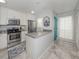 Well-lit kitchen features white cabinets, stainless steel appliances, granite countertops, and tile flooring at 418 Cerromar Ct # 158, Venice, FL 34293