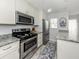 Kitchen features stainless steel appliances, granite countertops, white cabinets, and tiled floors at 418 Cerromar Ct # 158, Venice, FL 34293