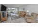Cozy living room with neutral paint, tile floors, comfortable seating, and sliding glass doors to a lanai at 418 Cerromar Ct # 158, Venice, FL 34293