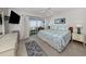 Bright main bedroom with a ceiling fan, TV, balcony access, and coastal-inspired decor at 418 Cerromar Ct # 158, Venice, FL 34293