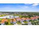 Panoramic aerial view of a residential area with homes, green spaces, and mature trees under a clear sky at 4378 Summertree Rd, Venice, FL 34293