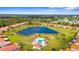 Aerial view of community featuring homes, lake with fountain, and a sparkling community pool at 4378 Summertree Rd, Venice, FL 34293