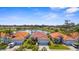 Aerial view of a home with a red tile roof overlooking a serene lake with a fountain and well-maintained landscaping at 4378 Summertree Rd, Venice, FL 34293