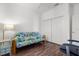 The bedroom features wood floors, a white closet, and a blue and green futon at 4378 Summertree Rd, Venice, FL 34293