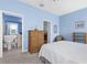 The bright bedroom includes a wicker dresser, an adjacent bathroom, and a comfortable sitting area at 4378 Summertree Rd, Venice, FL 34293
