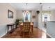 Bright dining room featuring hardwood floors, chandelier, and large window with curtains at 4378 Summertree Rd, Venice, FL 34293