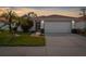 Charming single-story home with a well-manicured lawn, beautiful flowers, and a two-car garage at 4378 Summertree Rd, Venice, FL 34293