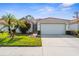 Charming single-story home with a well-manicured lawn, mature palm trees, and a two-car garage at 4378 Summertree Rd, Venice, FL 34293