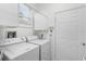 Clean laundry room with washer, dryer, white cabinets, and a window for natural light at 4378 Summertree Rd, Venice, FL 34293