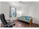 Comfortable office space featuring wood floors, a colorful futon, and a bright window at 4378 Summertree Rd, Venice, FL 34293