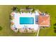 Aerial view of a pool area with lounge chairs, palm trees, and a covered structure for shade at 4378 Summertree Rd, Venice, FL 34293