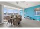 Sunroom with lake views, white wicker furniture, and cheerful blue accent wall at 4378 Summertree Rd, Venice, FL 34293