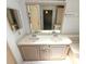 Bathroom with double sink vanity, large mirror, and neutral decor at 453 Sharks Pt, North Port, FL 34287