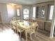 Well-lit dining room features a large table with seating for six, cabinet, and hardwood flooring at 453 Sharks Pt, North Port, FL 34287