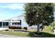 Quaint single-story home with white siding, lush landscaping, and a large tree in the front yard at 453 Sharks Pt, North Port, FL 34287