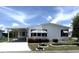 Charming single-story home with white siding, carport, well-manicured landscaping, and vibrant flowerbeds at 453 Sharks Pt, North Port, FL 34287