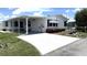 Inviting single-story home with a carport, well-kept white siding, and colorful flowerbeds in the front yard at 453 Sharks Pt, North Port, FL 34287