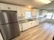 Modern kitchen featuring stainless steel appliances, granite counters, white cabinetry and hardwood floors at 453 Sharks Pt, North Port, FL 34287