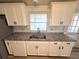 Kitchen with granite countertops, stainless steel sink and white cabinetry at 453 Sharks Pt, North Port, FL 34287