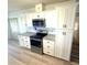 Updated kitchen featuring stainless steel appliances, granite countertops, and white cabinetry at 453 Sharks Pt, North Port, FL 34287