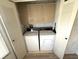 Convenient laundry area with washer, dryer, and overhead cabinets for storage at 453 Sharks Pt, North Port, FL 34287