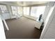 Enclosed sunroom with white vinyl walls, white furnishings, and neutral flooring at 453 Sharks Pt, North Port, FL 34287