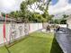 Backyard features artificial turf, white vinyl fencing, patio area, and attractive landscaping at 460 Bard Rd, Venice, FL 34293