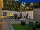 Backyard features artificial turf, white vinyl fencing, patio, lighting, and landscaping at 460 Bard Rd, Venice, FL 34293