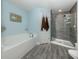 Serene bathroom with a soaking tub, a separate shower, and wood-look tile flooring at 460 Bard Rd, Venice, FL 34293
