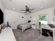 Cozy bedroom with grey carpet, a ceiling fan, and a small desk with plenty of natural light at 460 Bard Rd, Venice, FL 34293