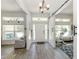 Bright foyer with wood-look tile flooring, a modern chandelier, and a sliding barn door at 460 Bard Rd, Venice, FL 34293