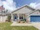 Charming home with a blue garage door, stone accents, and a welcoming porch at 460 Bard Rd, Venice, FL 34293