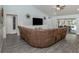 Spacious living room with vaulted ceilings, modern floors, ceiling fan, and a comfortable couch at 460 Bard Rd, Venice, FL 34293