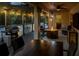 Cozy covered patio with a dining table, fire pit, outdoor kitchen, and string lights, ideal for evening gatherings at 460 Bard Rd, Venice, FL 34293