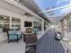 Covered outdoor patio with comfortable seating, a large television, and an outdoor kitchen for entertaining at 460 Bard Rd, Venice, FL 34293