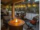 Covered patio features a fire pit, seating, lighting, and an outdoor grill at 460 Bard Rd, Venice, FL 34293