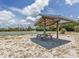 Community picnic shelter with seating, near the basketball court, ideal for outdoor gatherings and relaxation at 460 Bard Rd, Venice, FL 34293