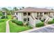Condo exterior showcasing manicured lawns, mature trees, and a serene residential setting at 4646 Longwater Chase # 98, Sarasota, FL 34235