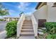 Exterior of this 2-story home featuring a concrete staircase leading to the front door surrounded by lush landscaping at 4646 Longwater Chase # 98, Sarasota, FL 34235