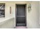 A close up of the front door with a WELCOME sign and flower arrangement providing a warm invite at 4646 Longwater Chase # 98, Sarasota, FL 34235