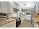 Bright kitchen featuring granite countertops, stainless steel appliances, and white cabinetry at 4646 Longwater Chase # 98, Sarasota, FL 34235