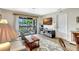 Living room leading to screened balcony, flat screen tv, and a comfortable chair at 4646 Longwater Chase # 98, Sarasota, FL 34235