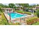 Community pool with an outdoor bathhouse, lush landscaping, and plenty of lounge chairs at 4646 Longwater Chase # 98, Sarasota, FL 34235